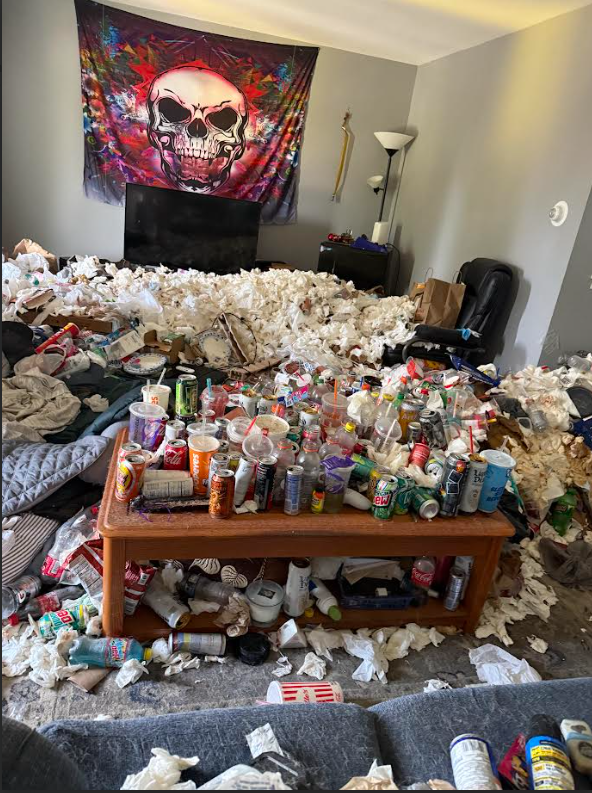Living room filled with accumulated trash and debris before professional hoarding cleanup.